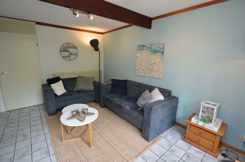 Lichte woonkamer van Bungalow Verste Coogh 56, De Dennen, Texel, met moderne inrichting en sfeervolle verlichting.