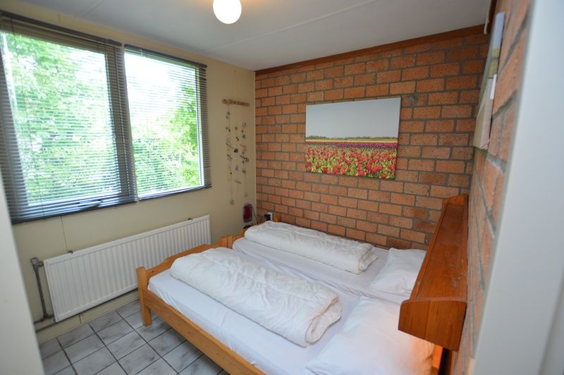 Slaapkamer in Bungalow Verste Coogh 56, De Dennen, Texel, met comfortabel tweepersoonsbed en rustgevende sfeer.