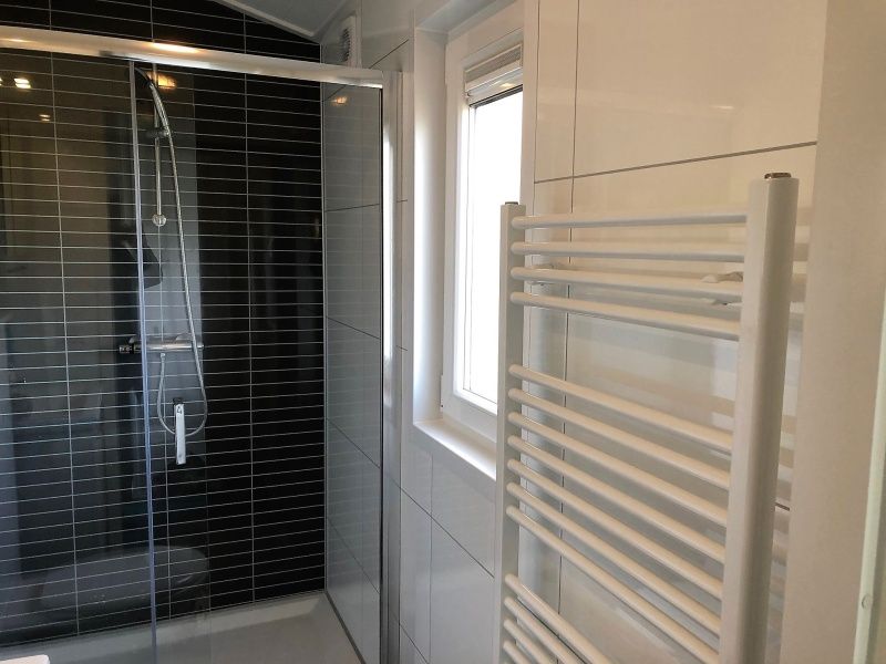 Moderne badkamer in Vakantiepark de Bremakker - Bosveld 103, vakantiehuis in De Dennen, Texel, met luxe douche en handdoekradiator.