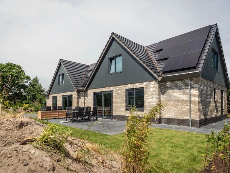 Buitenzijde van Vakantiepark De Koorn-aar Villa in De Dennen Texel met terras en groene omgeving.