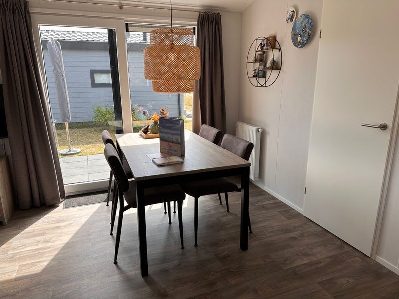 Essecke mit Blick auf die Terrasse im Chalet Wulk, Vakantiepark de Bremakker, Texel, ideal fuer Familienessen.