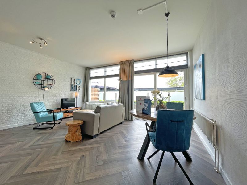 Heller Essbereich im Apartment Bos en Duin 03, De Dennen, Texel mit Blick auf den Garten und viel Tageslicht.