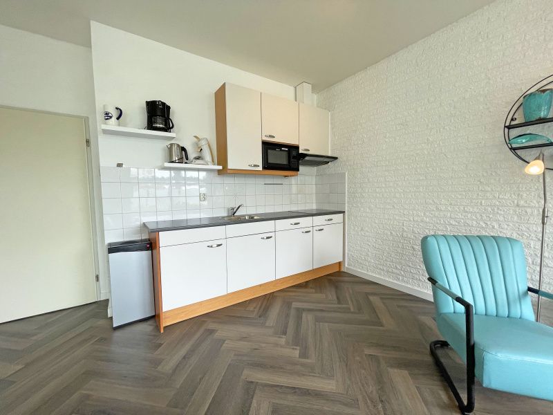 Kompakte Kueche im Apartment Bos en Duin 03, De Dennen, Texel mit modernen Geraeten und stilvollem Dekor.