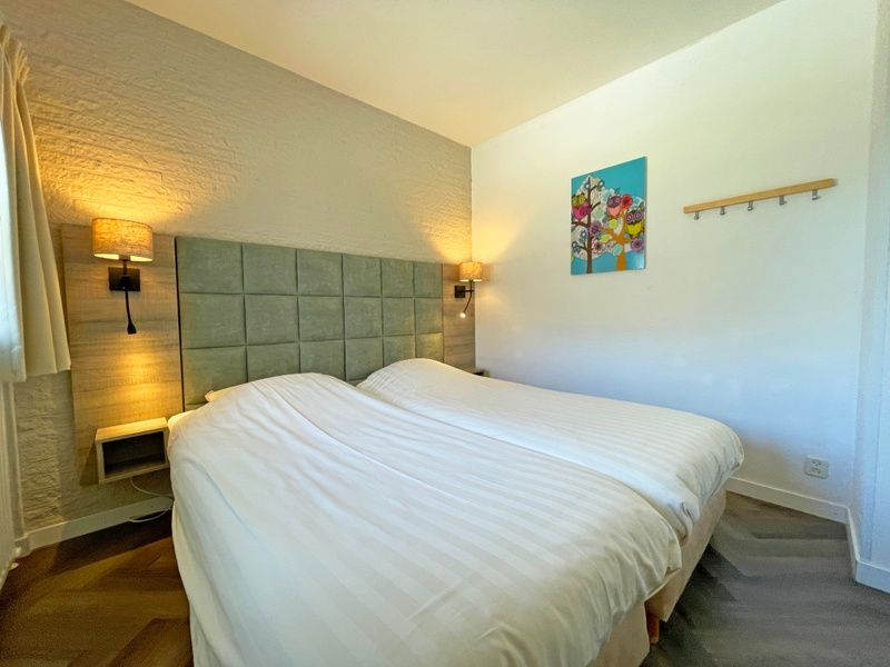 Gemuetliches Schlafzimmer im Appartement Bos en Duin 03, De Dennen, Texel mit Doppelbett und stimmungsvoller Beleuchtung.