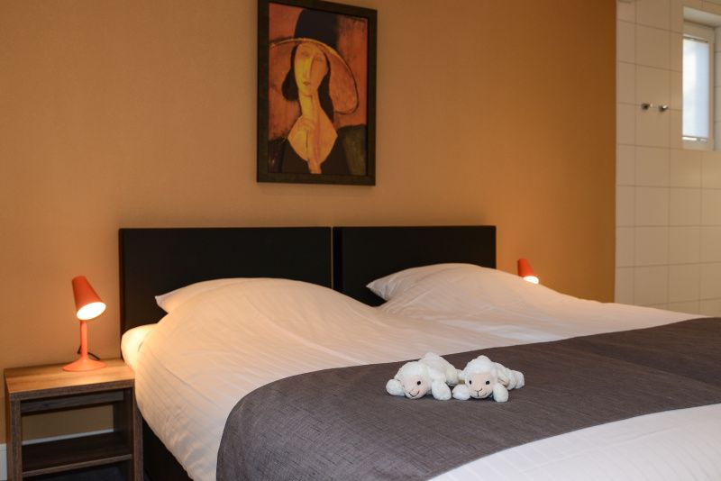 Gemuetliches Schlafzimmer mit Kunst an der Wand im Bungalowpark 't Hoogelandt - De Zandkes, De Dennen, Texel.