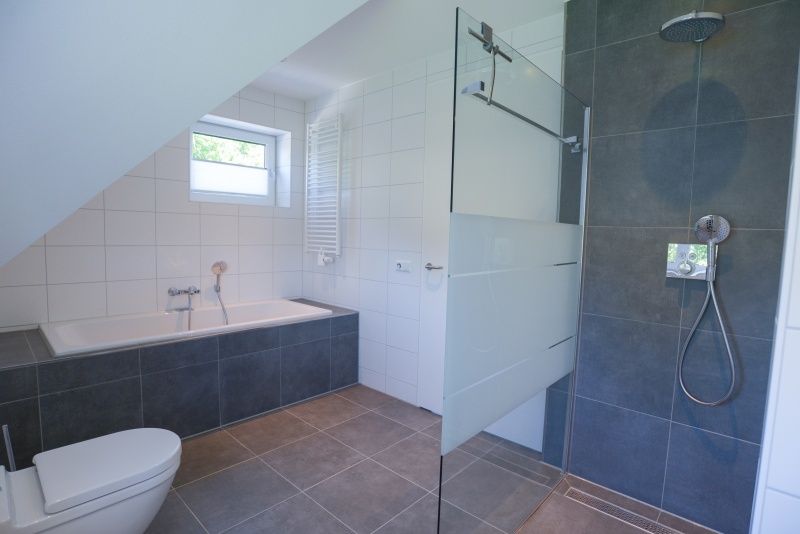 Modernes Badezimmer mit Dusche und Badewanne im Bungalowpark 't Hoogelandt - De Zandkes, De Dennen, Texel fuer hoechsten Komfort.