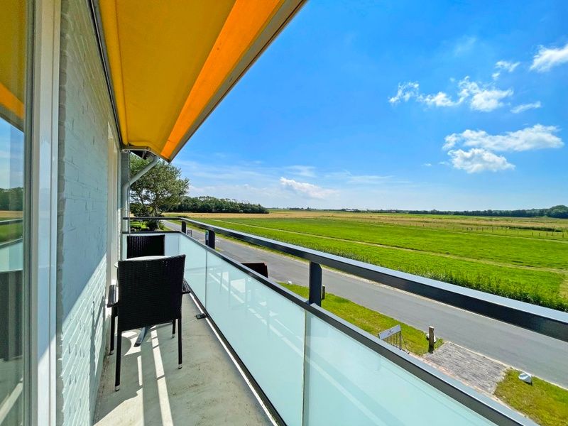 Luftaufnahme des Appartements Bos en Duin 16 in De Dennen Texel mit der umgebenden gruenen Umgebung.