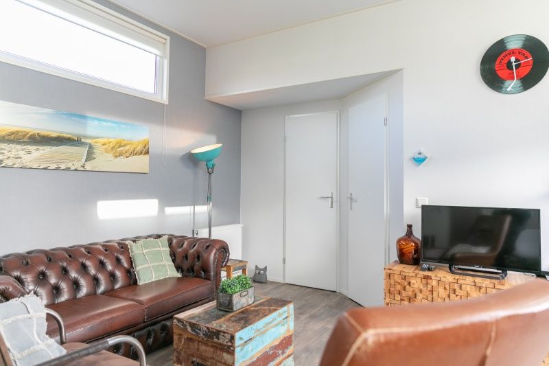 Gezellige woonkamer in Chalet Julie bij Vakantiepark de Bremakker, De Dennen, Texel. Comfortabele zithoek met moderne inrichting.