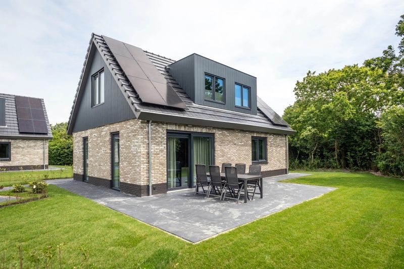 Vakantiehuis met zonnig terras in Vakantiepark De Koorn-aar, Texel, omringd door natuur.