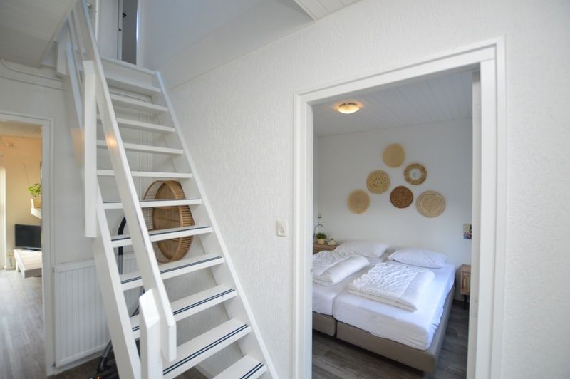 Bedroom and stairs in vacation home Gerritslanderdijkje 146 - Salty Dog, De Dennen, Texel with bright decor.