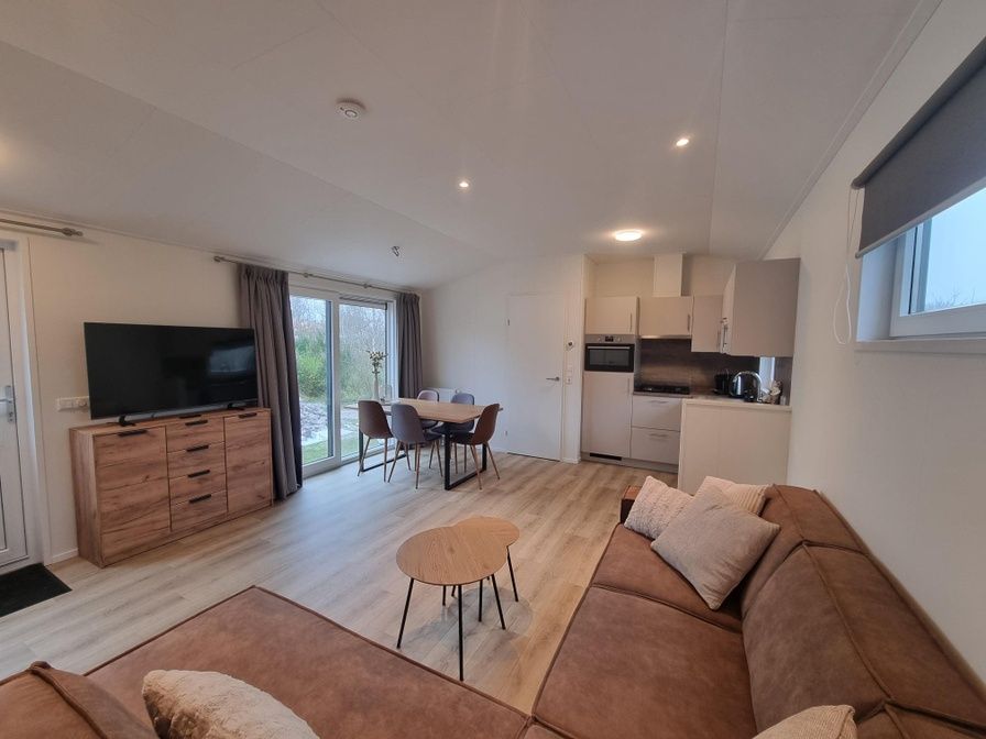Gezellige woonkamer in Vakantiepark de Bremakker, Weideveld 75, Texel met moderne keuken en comfortabele zithoek.