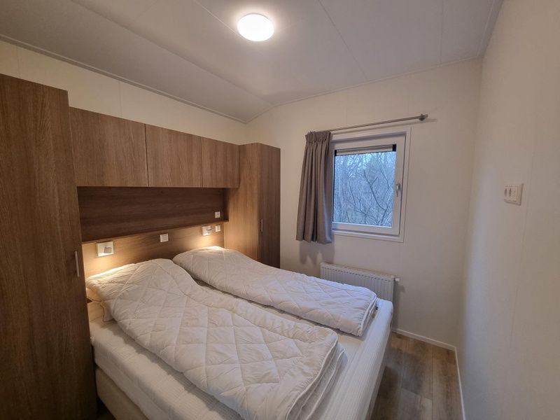 Sfeervolle slaapkamer met tweepersoonsbed in Vakantiepark de Bremakker, Weideveld 75, Texel, omringd door natuur.