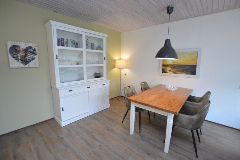 Stijlvolle eetkamer in vakantiehuis Roos, De Dennen, Texel met houten tafel.