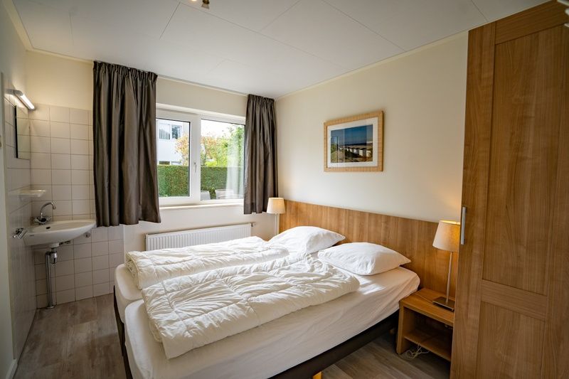 Gemuetliches Schlafzimmer im Ferienhaus 't Hoogelandt 134A, De Dennen, Texel mit Doppelbett.