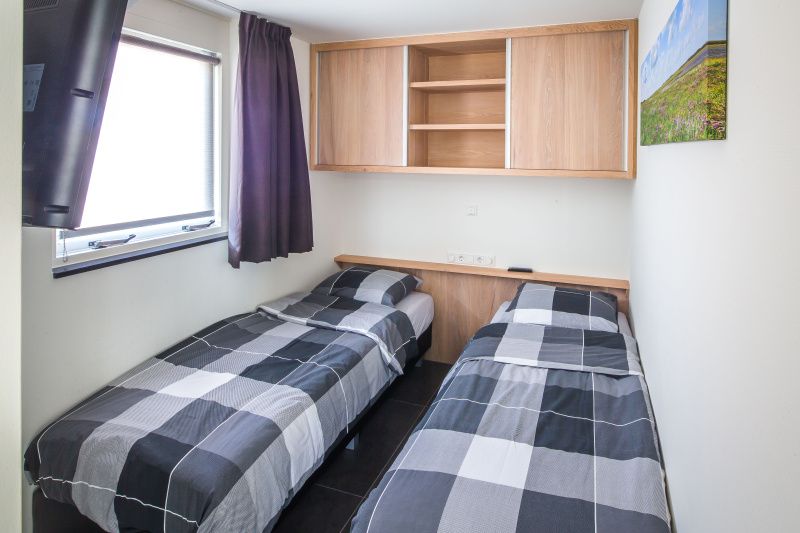 Comfortabele slaapkamer met twee bedden in vakantiehuis Gortersmient 206, Texel.