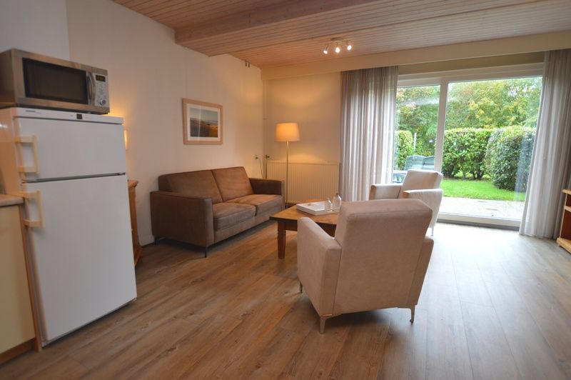 Comfortabele zitruimte in vakantiehuis Anjer, De Dennen, Texel met uitzicht op de tuin.