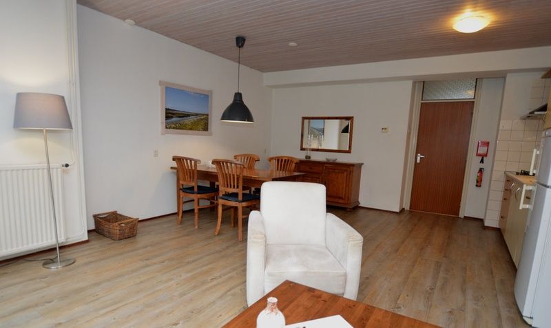 Eethoek van vakantiehuis Anjer in De Dennen, Texel met houten tafel en stoelen.