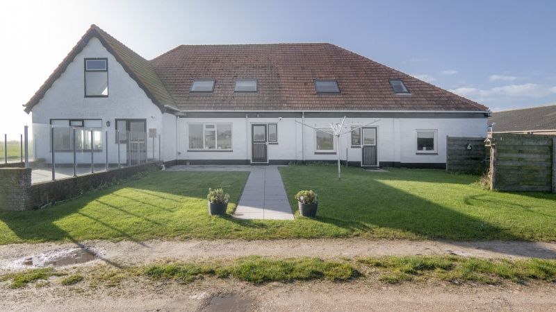 Vorderseite des Ferienhauses Hans in De Dennen, Texel mit gruenem Garten.