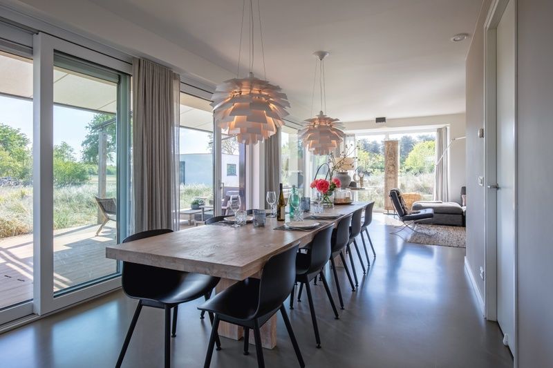 Eetkamer met grote tafel in Villa Serendipity, vakantiehuis in De Dennen, Texel, ideaal voor familiediners.