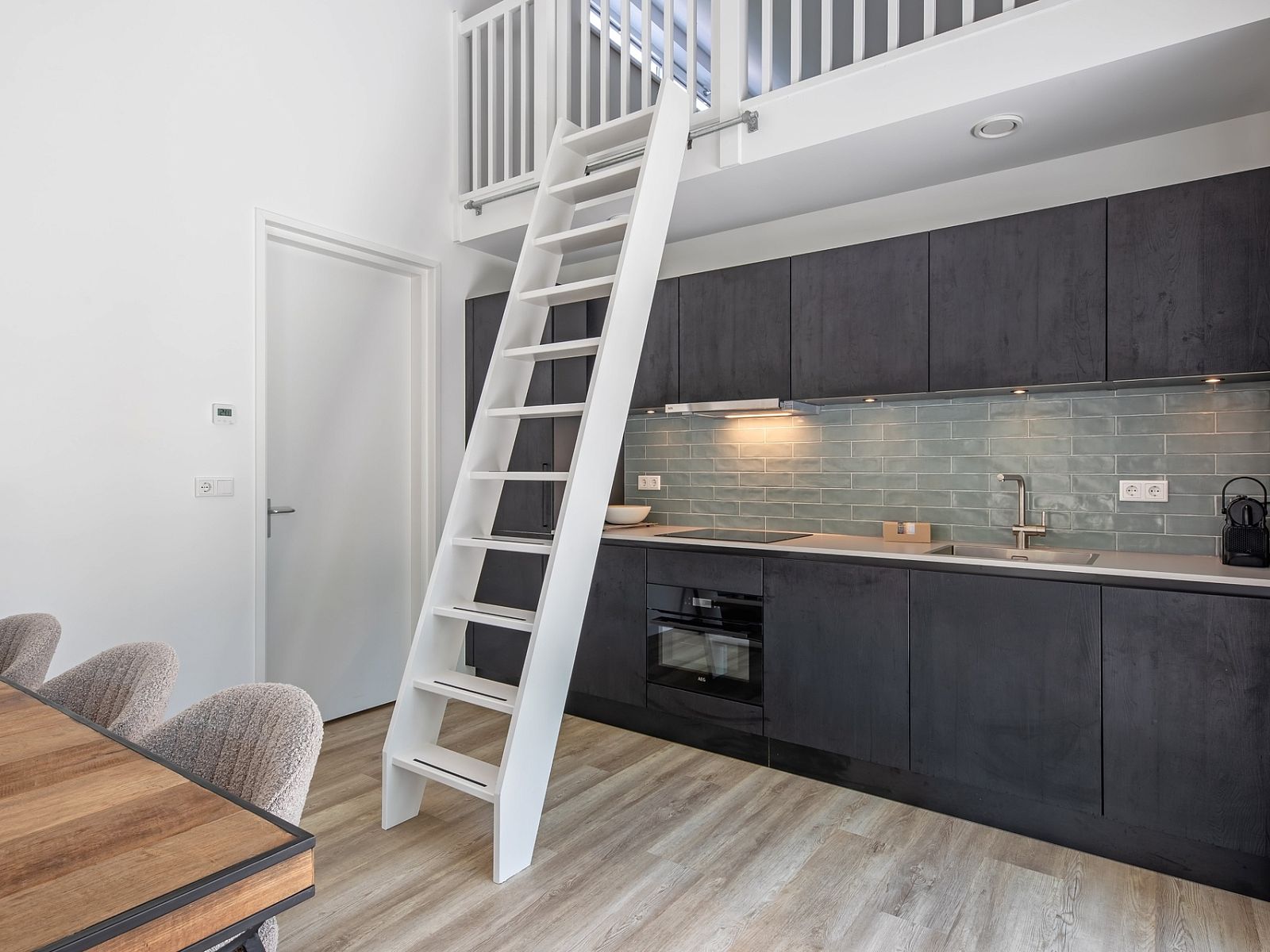 Open keuken en trap naar loft in Tormentil vakantiewoning, De Dennen, Texel.