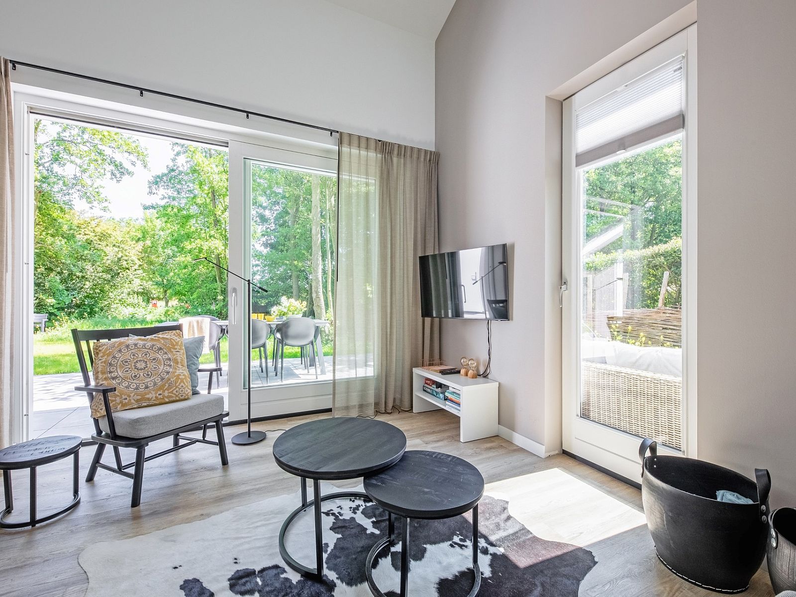 Woonkamer van Tormentil in De Dennen, Texel met uitzicht op de tuin.