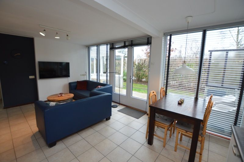 Lichte woonkamer in Vakantiehuis de Parel 244, De Dennen, Texel met comfortabele zithoek en eetgedeelte.