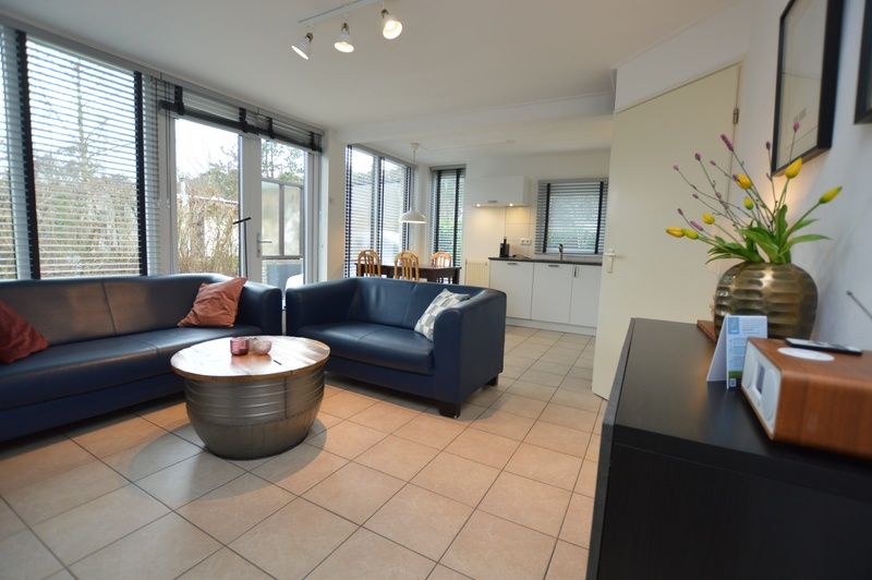 Gezellige leefruimte in Vakantiehuis de Parel 244, De Dennen, Texel met uitzicht op de tuin.