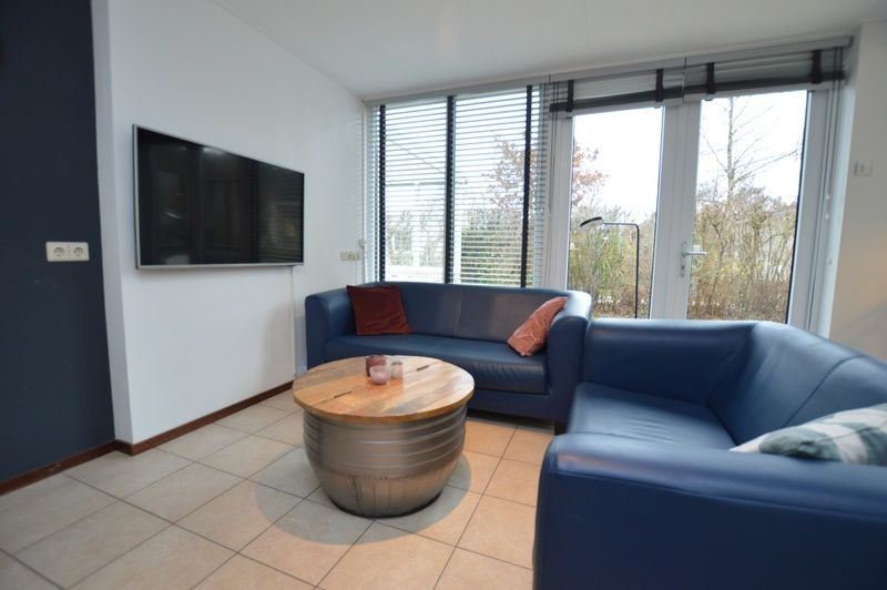 Comfortabele zithoek met tv in Vakantiehuis de Parel 244, De Dennen, Texel, ideaal voor ontspanning.