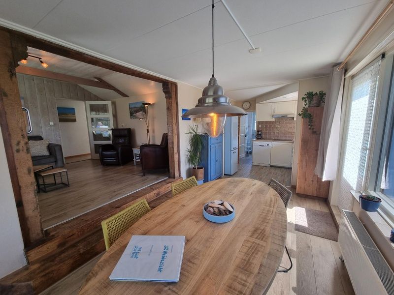 Dining area in Weidezicht vacation home, De Dennen, Texel with wooden table and lots of light.