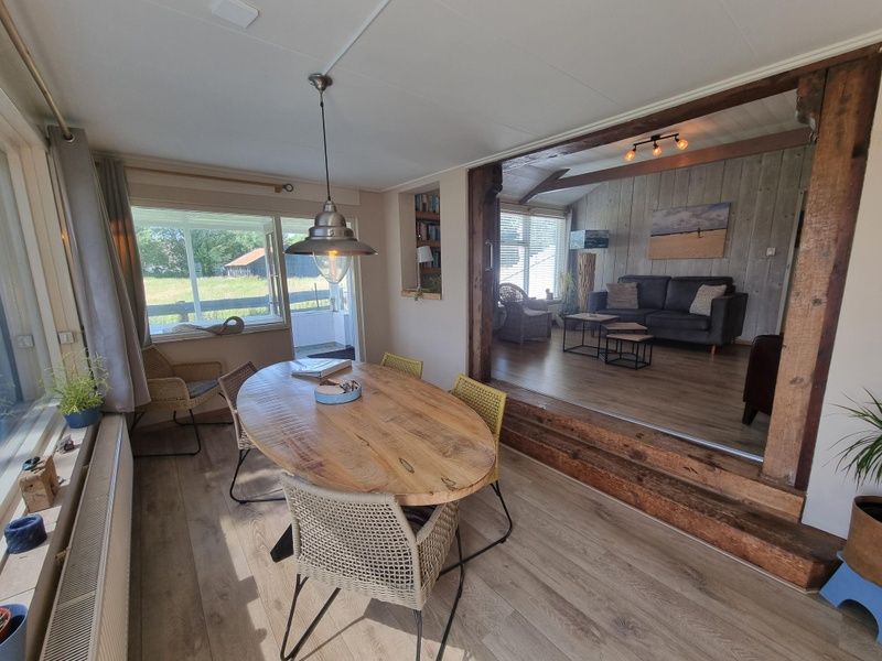 Cozy dining area in Weidezicht vacation home, De Dennen, Texel with views of the surroundings.