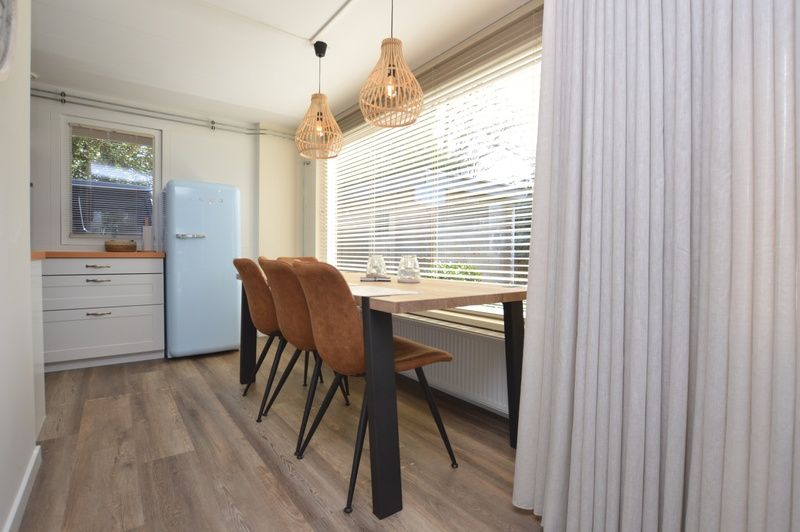 Eetkamer in Bungalow Verste Coogh 58, Texel met moderne meubels en veel natuurlijk licht.