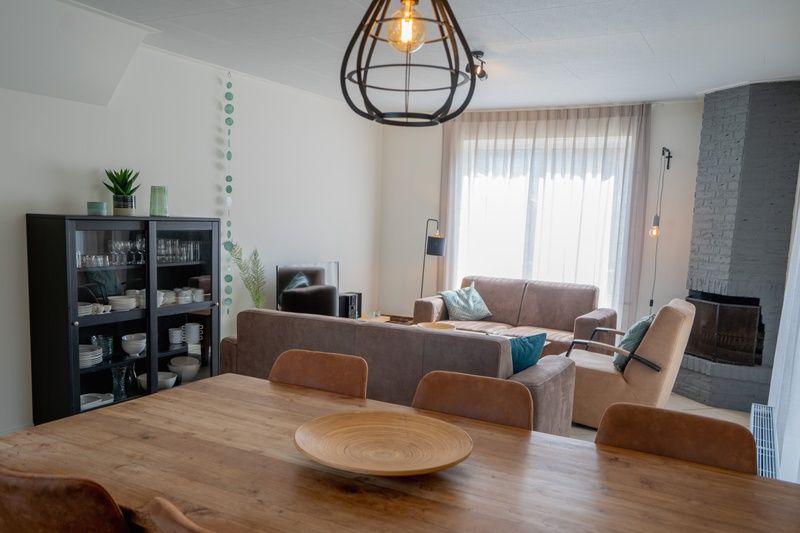 Dining room and living room of Holiday Home 't Hoogelandt 136A in De Dennen, Texel with atmospheric lighting.