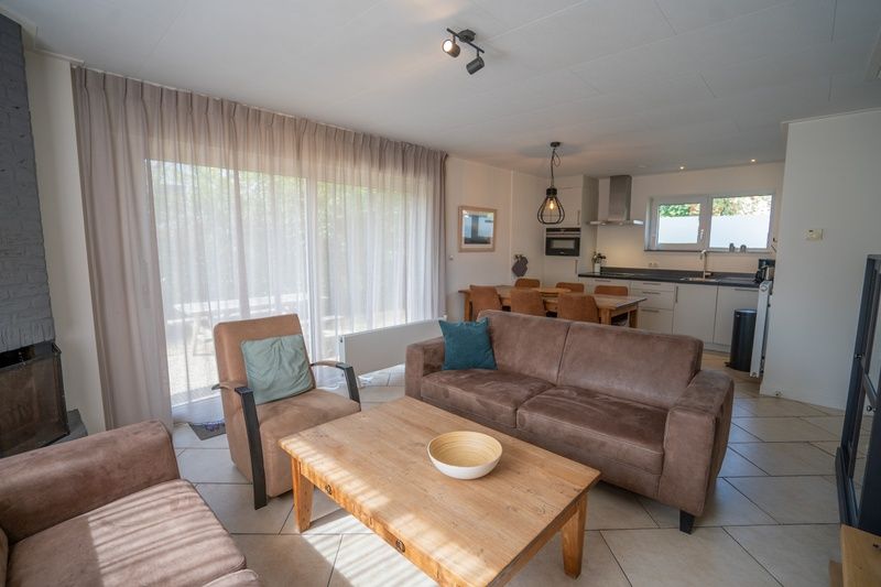 Bright living room of Holiday Home 't Hoogelandt 136A in De Dennen, Texel overlooking the garden.