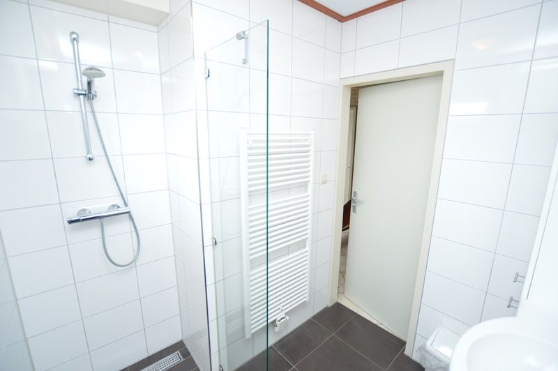 Stylish bathroom in Holiday Home 't Hoogelandt 136A, De Dennen, Texel with shower and sink.