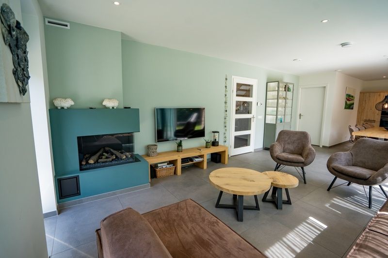 Gemuetliches Wohnzimmer des Ferienhauses de Parel 174 in De Dennen, Texel mit moderner Einrichtung und Kamin.