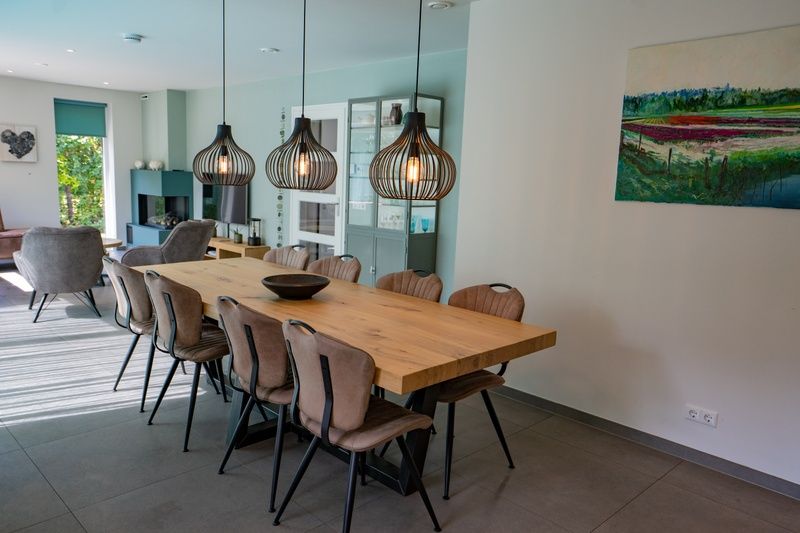 Esszimmer mit Holztisch und stimmungsvoller Beleuchtung im Ferienhaus de Parel 174, De Dennen, Texel.