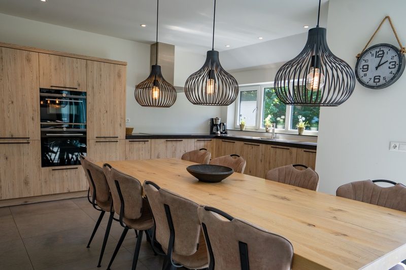 Moderne Kueche mit grossem Esstisch im Ferienhaus de Parel 174, gelegen in De Dennen, Texel.