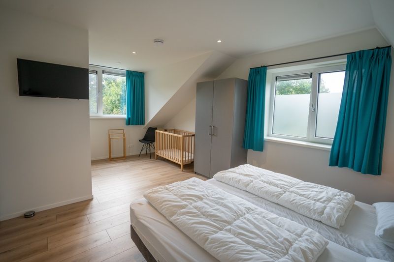 Geraeumiges Schlafzimmer mit Kinderbett im Ferienhaus de Parel 174, De Dennen, Texel auf den Watteninseln.