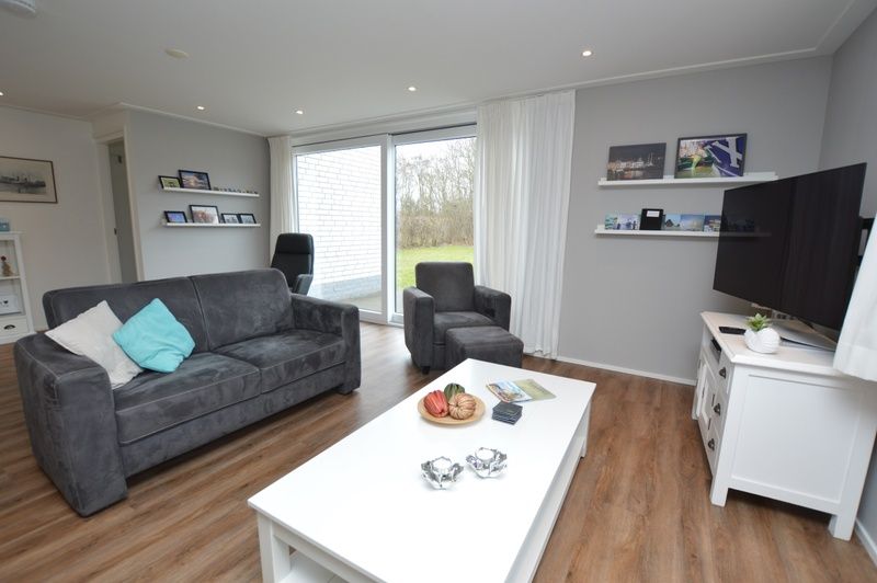 Gemuetliches Wohnzimmer mit Blick auf den Garten im Ferienhaus de Parel 168, De Dennen, Texel, ideal fuer die Familie.