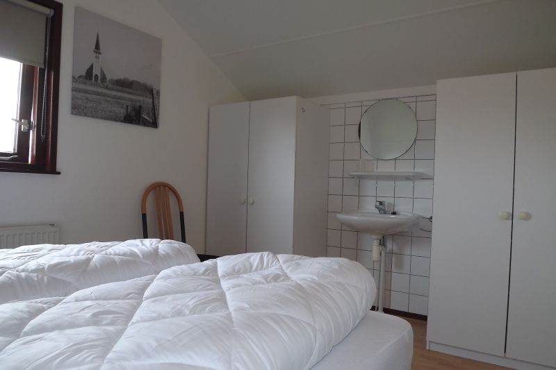 Stilvolles Schlafzimmer mit Waschbecken im Ferienhaus Gortersmient 234, Texel.