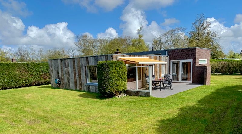 Blick auf das Ferienhaus Hesselte in De Dennen, Texel, umgeben von viel Gruen.