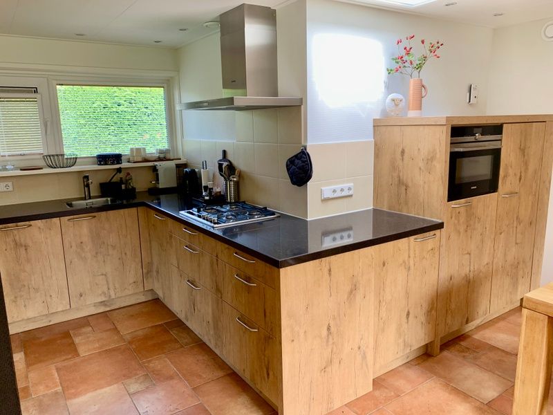 Moderne Kueche im Ferienhaus Hesselte, De Dennen, Texel mit Holzschraenken.