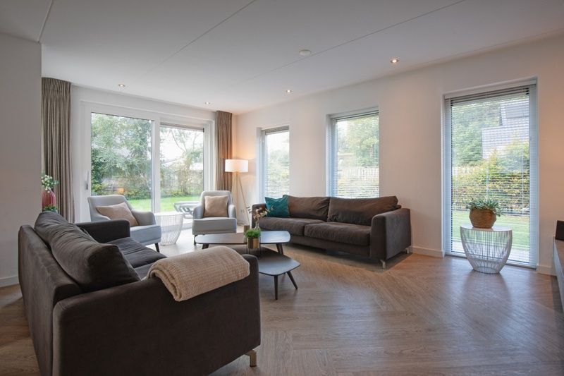 Gemuetliches Wohnzimmer in der Villa Bloem en Bos, Bungalowpark 't Hoogelandt, De Dennen, Texel, mit viel Tageslicht und Gartenblick.