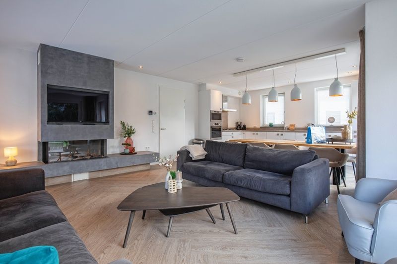 Gemuetliche Sitzecke in der Villa Bloem en Bos, Bungalowpark 't Hoogelandt, De Dennen, Texel, mit modernem Mobiliar und Kamin.