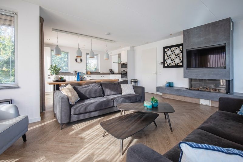 Open keuken en zitgedeelte in Villa Menno, Bungalowpark 't Hoogelandt, Texel, met comfortabele bank.