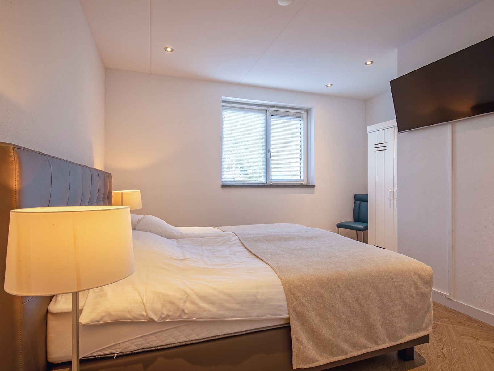 Ruime slaapkamer met televisie in Villa Menno, Bungalowpark 't Hoogelandt, De Dennen, Texel.