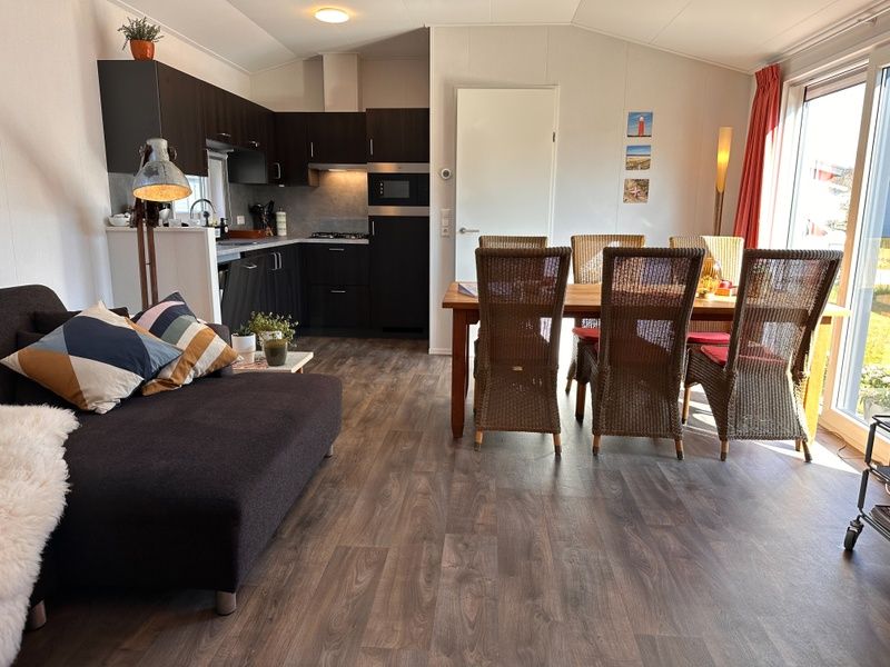 Vakantiepark de Bremakker - Bosveld 141, geraeumiges Esszimmer im Ferienhaus De Dennen, Texel mit Blick auf den Garten.