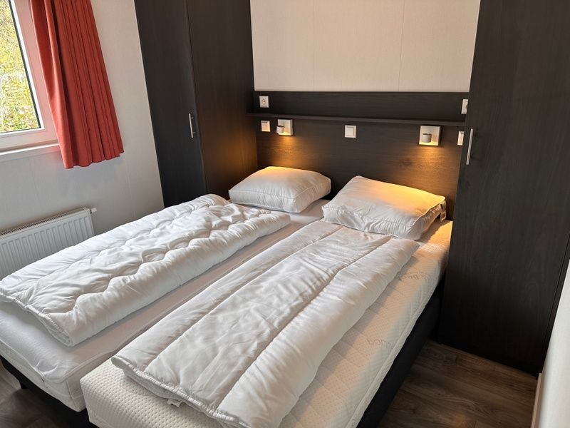 Vakantiepark de Bremakker - Bosveld 141, gemuetliches Schlafzimmer im Ferienhaus De Dennen, Texel mit Doppelbett und Stimmungsbeleuchtung.