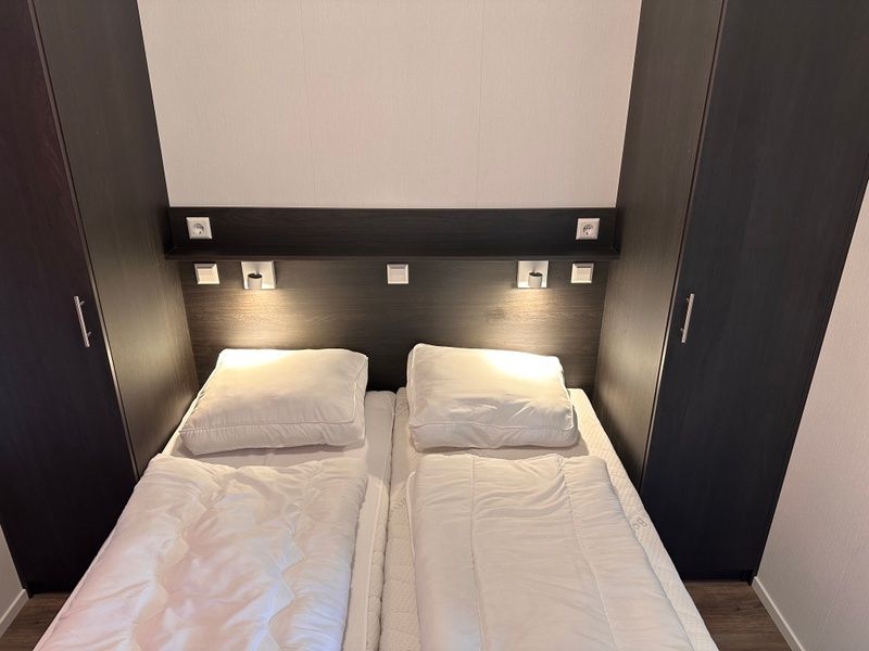 Vakantiepark de Bremakker - Bosveld 141, modernes Schlafzimmer im Ferienhaus De Dennen, Texel mit bequemem Bett und Stauraum.