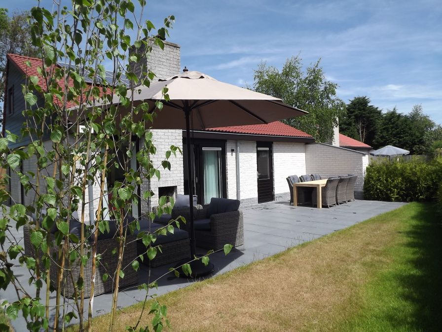 Gezellig terras bij Vakantiehuis Gortersmient 322 in De Dennen, Texel, met comfortabele zitjes en parasol.
